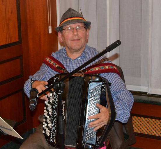 Ich sitze auf dem Stuhl und spiele,  vor  mir steht der Mikrofonständer und ich schaue die Tanzpaare an.